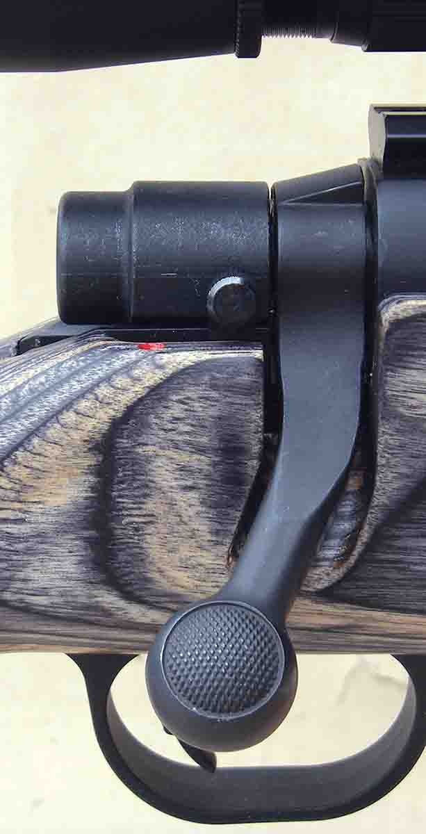 The rifle has a two-position safety and the bolt handle is swept back
